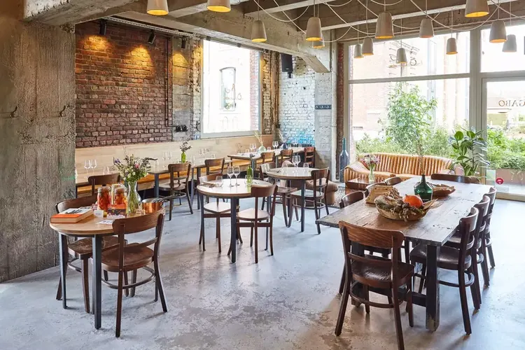 La salle du Gabo : briques, béton et tables de bistrot.